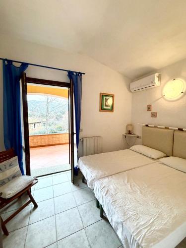 a bedroom with two beds and a door to a balcony at Casa vacanza Oleandro in San Teodoro