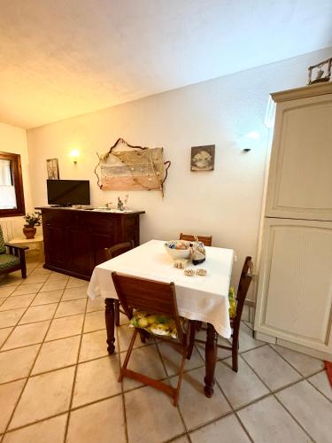 a dining room with a table and chairs and a tv at Casa vacanza Oleandro in San Teodoro