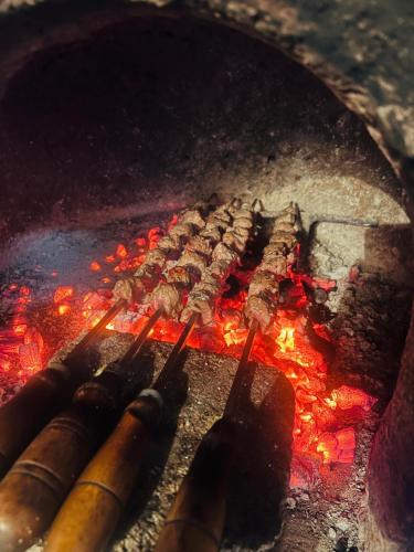 a row of meat cooking on top of a grill at IlhaMontanha - Serras da Ilha in Santana