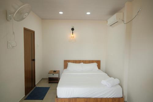 a bedroom with a white bed in a room at The Varghese Beth in Munroe Island