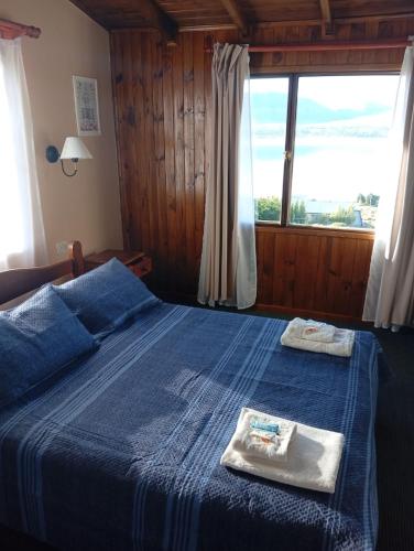 a bedroom with a blue bed with towels on it at Altos de Soberana in El Calafate
