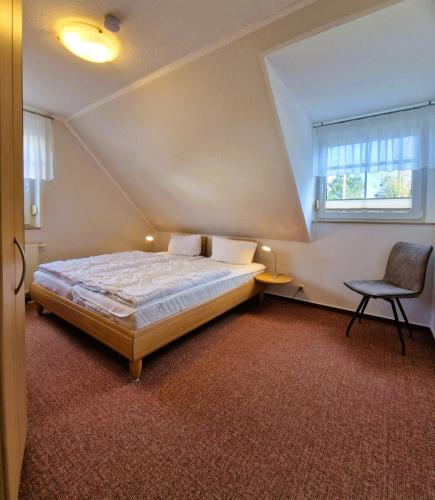 a bedroom with a bed and a chair and a window at _Neue Liebe_ Wohnung 3 in Groß Kirr