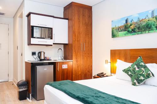 a hotel room with a bed and a kitchen at Umhlanga Apart Hotel in Durban