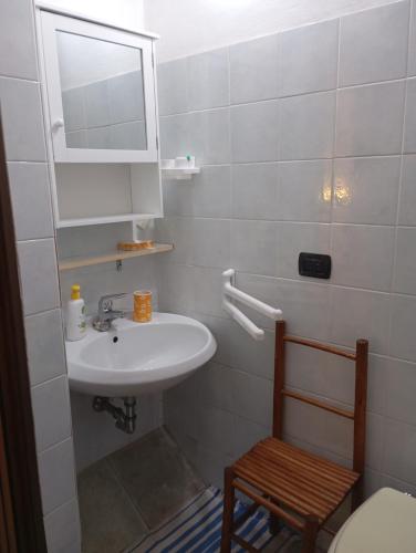 a bathroom with a sink and a mirror and a chair at In Sardegna da Anna Rita in Scano Montiferro