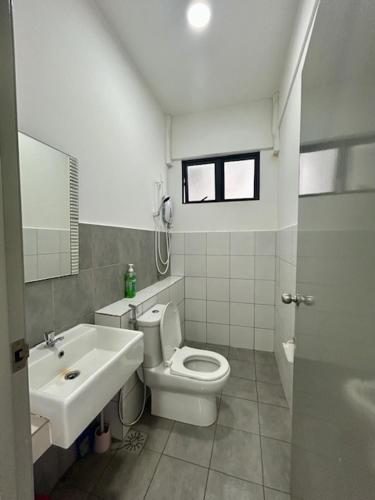 a bathroom with a white toilet and a sink at PeaceStay in Sandakan
