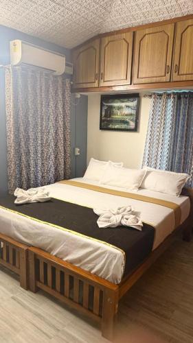 a large bed in a bedroom with wooden cabinets at Thanal Home Stays in Kollam