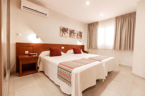 a hotel room with a large bed and a window at Apartamentos Vista Sur in Playa de las Americas