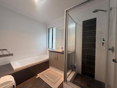 a bathroom with a tub and a sink and a shower at Sweet Home Property Forrestfield in Perth