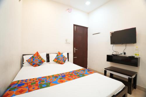 a bedroom with a bed and a tv on the wall at FabHotel Gold Residency in Chennai