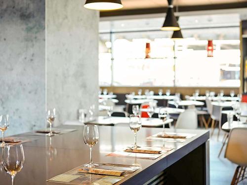 a row of wine glasses sitting on a counter in a restaurant at ibis Birmingham Airport Terminal Building - NEC in Bickenhill