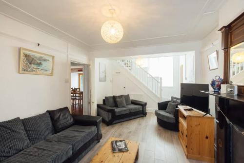 a living room with a couch and a table at Cosy Welsh Cottage in St Davids Centre with Garden in St. Davids