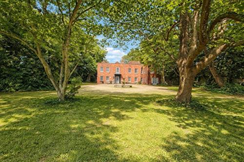 a red brick building with a picnic table and trees at Royal Windsor Country Estate Private 5 Acres of Gardens in Windsor