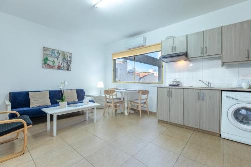 a kitchen and living room with a couch and a table at Tiffany City Apartments in Larnaca
