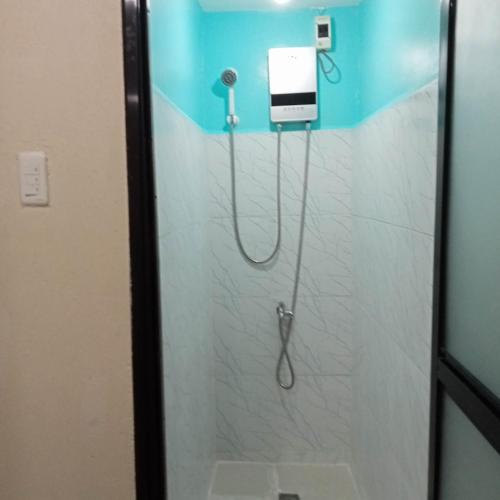 a shower with a hose in a bathroom at Moalboal Homestay VILLA in Tomonoy