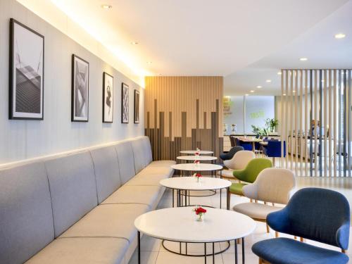 a waiting room with tables and chairs at ibis Bangkok Sathorn in Bangkok