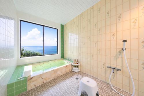 a bathroom with a tub and a window at 絶景貸切別荘in山海荘 無料専用BBQスペースと駐車場付 in Shirahama