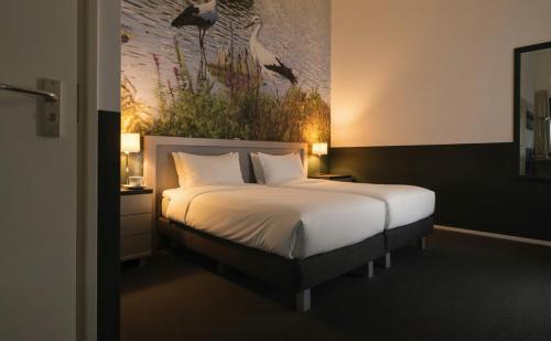a bedroom with a bed with a painting on the wall at B&B In de Kathoek in Blokzijl