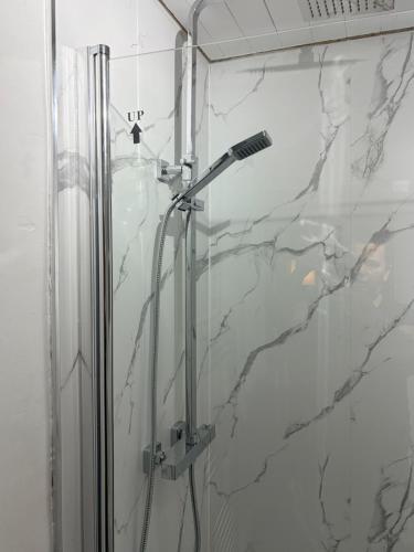 a bathroom with a shower with a glass door at The Dearham Lonnin Nook in Dearham