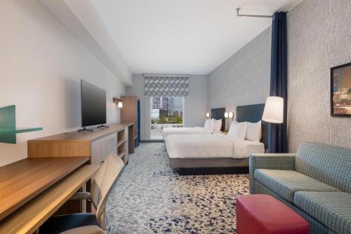 a hotel room with a bed and a tv at Home2 Suites By Hilton Houston Downtown Convention Center in Houston