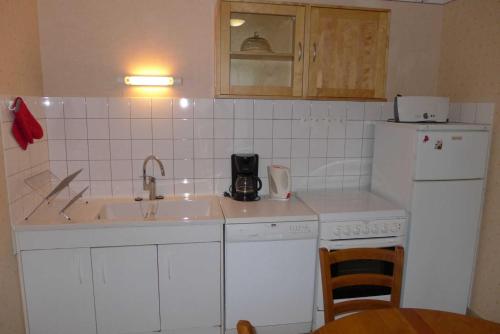 a small kitchen with a sink and a refrigerator at Valériane in Froncles