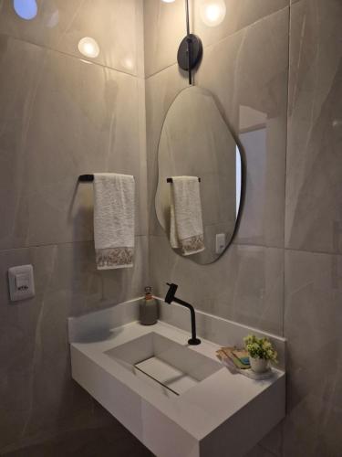 a bathroom with a sink and a mirror at Kitnet Vale do Amanhecer - Templo Mãe in Planaltina