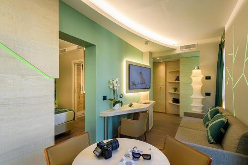 a room with two tables and chairs and a bed at Color Hotel Style, Design & Gourmet in Bardolino