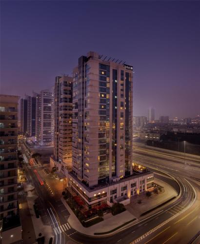 a tall building with lights on in a city at Radisson Blu Hotel, Dubai Barsha Heights in Dubai