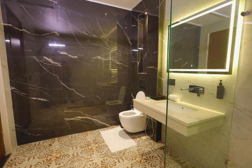 a bathroom with a sink and a toilet and a mirror at BB Grand in Sunām