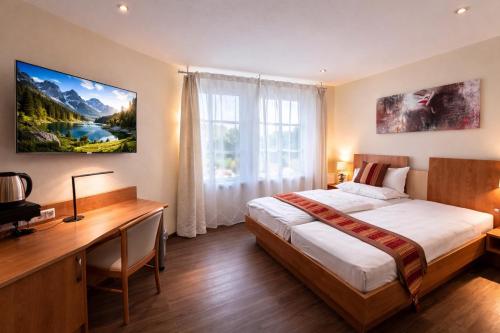 a bedroom with a bed and a desk and a window at Boutique Hotel Wolfsburg in Wolfsburg