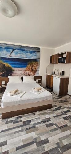 a bedroom with a bed with a painting on the wall at Флора Поморие in Pomorie