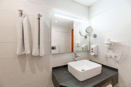 a white bathroom with a sink and a mirror at Apartamentos Vista Sur in Playa de las Americas