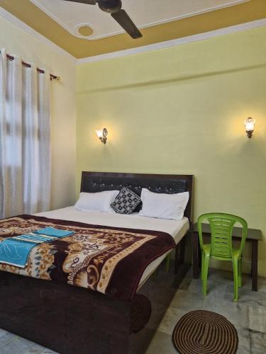 a bedroom with a bed and a green chair at Narayan homestay guesthouse in Ayodhya