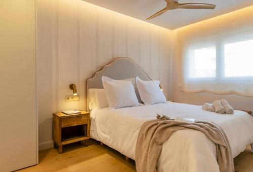 a bedroom with a large white bed with a window at Apartamento Pink Frontline Premium in Torrevieja