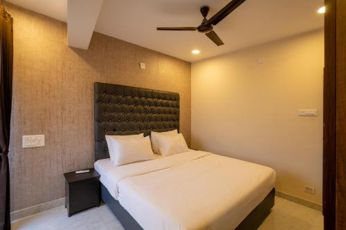 a bedroom with a large bed with a black headboard at Aafiya lakeview Apartments in Coimbatore