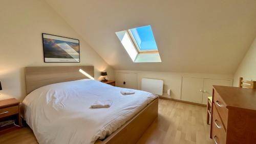 a bedroom with a large bed with two skylights at Maison duplex centre plage port cabine in Le Crotoy