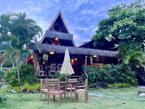 a restaurant with a table and chairs and an umbrella at MAMBEMBE hostel - Ilha Grande, Vila do Abraão in Abraão
