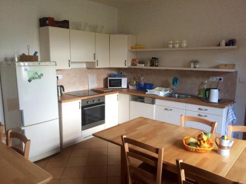 a kitchen with a table and a white refrigerator at Penzion Dolní Dunajovice in Dolní Dunajovice