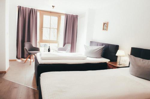 a hotel room with two beds and a window at Haus Luna - Apartment Luna 6 in Schwangau