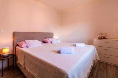 a bedroom with a large bed with pink pillows at Apartment Petar in Kaštela