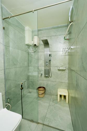 a shower with a glass door in a bathroom at Velan Temple View in Palni