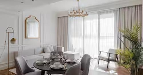 a white living room with a table and a couch at Burj Khalifa View & Creek lagoon in Dubai
