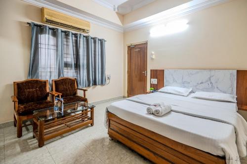 a bedroom with a bed and a chair and a table at Laxman Avenue in Jagdalpur