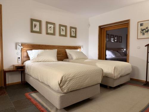 a bedroom with two beds and a couch at Casa Vidinha in Faria de Baixo