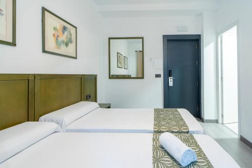 a bedroom with two beds and a mirror at Lantana Garden in Pilas
