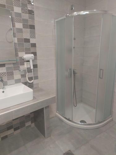 a bathroom with a shower and a sink at Karafelas rooms in Skiathos