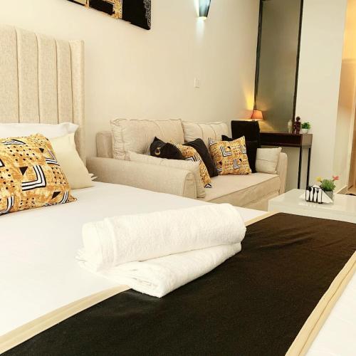 a living room with a white bed and a couch at Brizelle studio in Ongata Rongai 