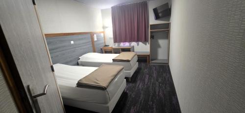 a hospital room with two beds and a couch at Hôtel Siatel Besançon Chateaufarine in Besançon