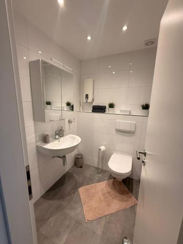 a white bathroom with a sink and a toilet at Appartement-Koblenz in Koblenz
