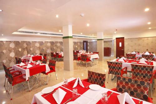 a restaurant with red and white tables and chairs at Hotel Indraprastha, Pattazhy in Avanīsvaram