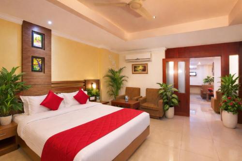 a hotel room with a large bed with red pillows at Hotel Indraprastha, Pattazhy in Avanīsvaram